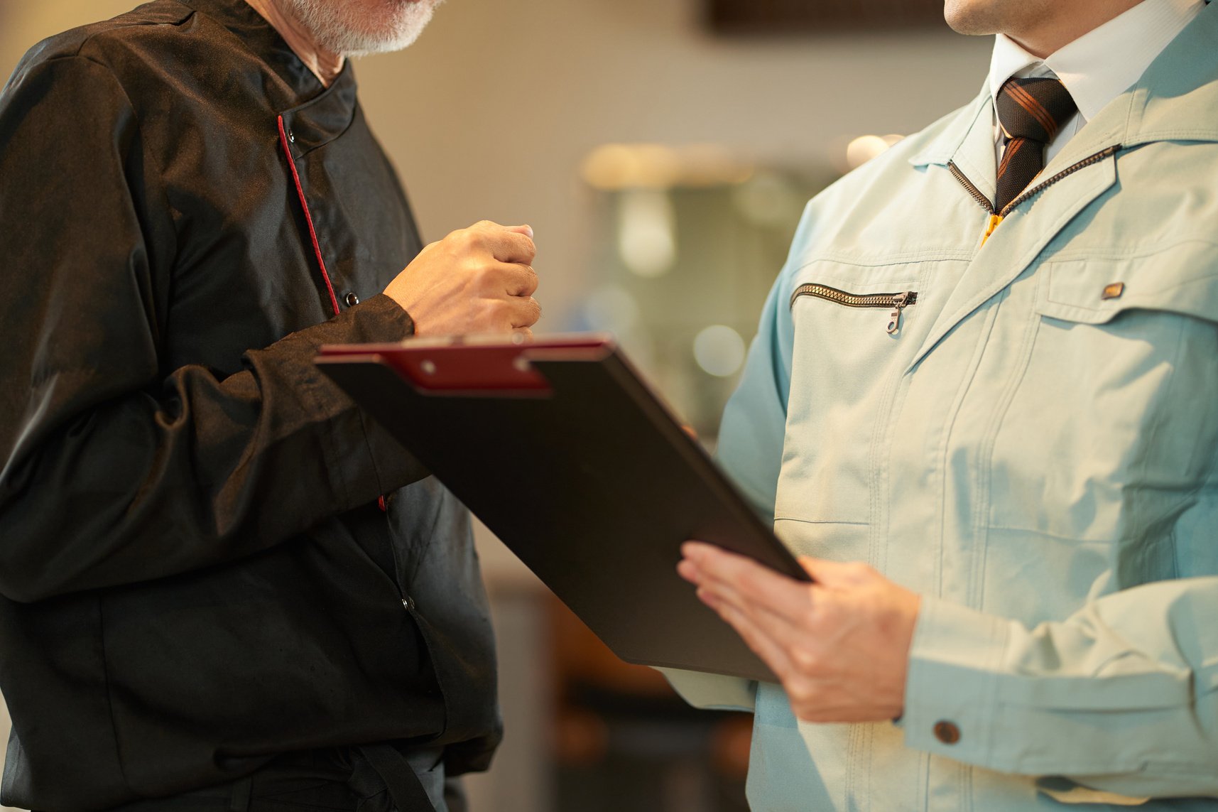 Asian man inspecting restaurant equipment
